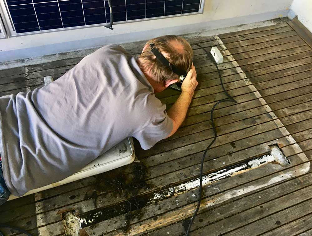 Wayne using a router to remove the old caulking. This was much easier than how he started, using a reefing hook.